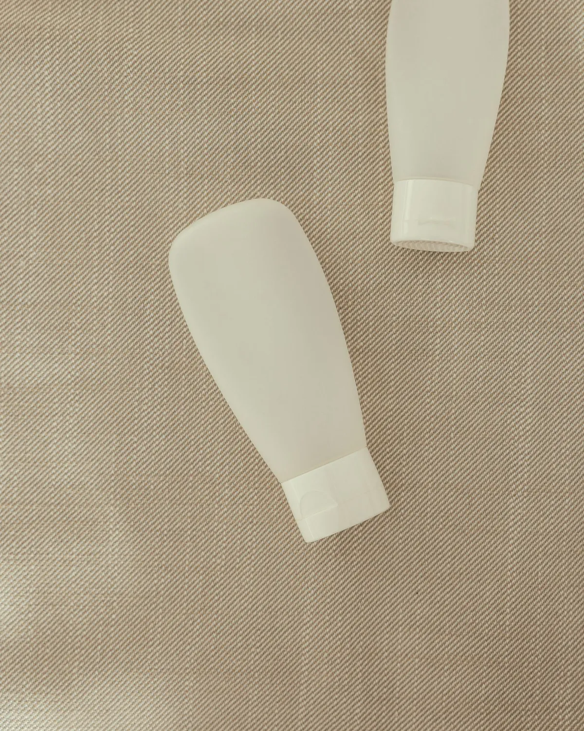 soft squeeze tubes of facial cleanser on linen